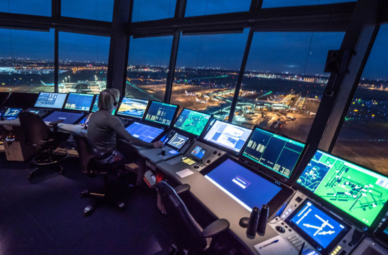 Air Traffic Control tower at an airport illuminated against the night sky